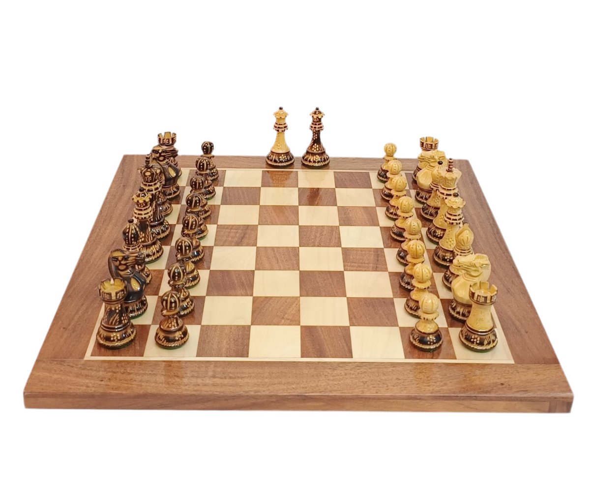 Classic Staunton chess pieces in burnt boxwood on a wooden chessboard, featuring a 3.9" king, ready for play.