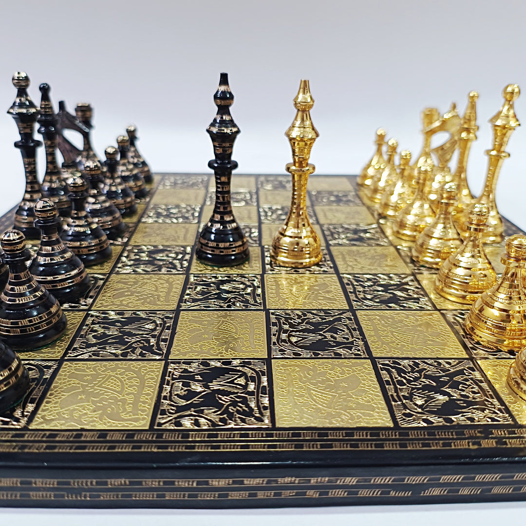 Egyptian themed brass chess set with black and gold pieces, intricate designs on the board, leatherette storage.