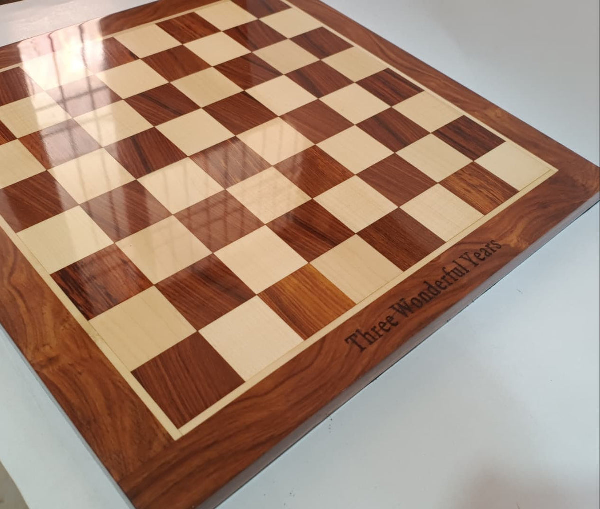 Wooden chess board with checkered pattern on a white surface