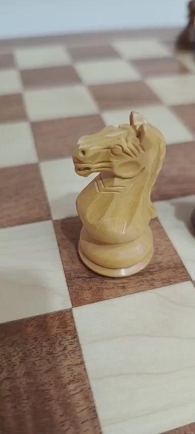 Close-up of a Supreme / Fierce Knight Staunton chess piece on a wood chessboard, showcasing intricate craftsmanship.